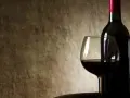 Kieliszek z czerwonym winem i butelka na tle. Czy czerwone wino się chłodzi?