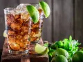 Dwa orzeźwiające drinki z rumem i lodem, ozdobione limonką. Idealne na upalne dni, zastanawiasz się, jaki rum do herbaty będzie najlepszy?