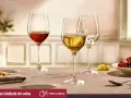 Trzy kieliszki z winem: czerwonym, białym i pusty. Obok talerz z winogronami. Idealne pytanie: jakie wino do tatara?