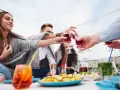 Grupa przyjaciół wznosi toast czerwonymi drinkami. Czy to już czas na digestif co to?