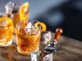 Trzy szklanki z rumem i lodem, ozdobione skórką pomarańczy. Idealne, by dowiedzieć się, jak pić rum.