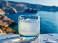 Szklanka orzeźwiającego ouzo z lodem, idealna na greckie wakacje. Zastanawiasz się, ouzo ile ma procent? Zazwyczaj 40-50%.