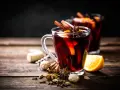 Rozgrzewający alkohol na ciepło, czyli aromatyczny grzaniec z pomarańczą i przyprawami korzennymi, na drewnianym stole.