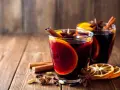 Dwa szklane kieliszki z grzanym winem, ozdobione plastrami pomarańczy, laskami cynamonu i anyżem. Idealne naczynia, w czym podawać grzane wino.