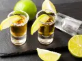 Dwa kieliszki tequili z solą i limonką, gotowe do degustacji. Czas sprawdzić, jak smakuje tequila!