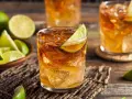 Idealny drink z rumem: orzeźwiający rum z lodem i limonką, obok miseczka z ćwiartkami limonki.