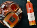 Brandy vs Cognac: butelka Pliska XO Brandy i Frapin Fontpinot XO Cognac, dwa kieliszki z bursztynowym trunkiem.