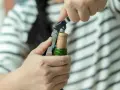 Ręce otwierają butelkę prosecco korkociągiem. Prosty sposób, jak otworzyć prosecco, by zacząć świętowanie.