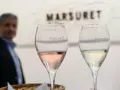 Dwa kieliszki z winem musującym: różowym i białym, z logo Marsuret. Różne rodzaje win musujących na degustacji.