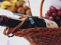 Koszyk z winem i winogronami. Idealny zestaw, jeśli zastanawiasz się, jakie wino do wołowiny wybrać.