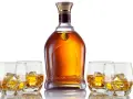 Elegancka butelka whisky i cztery szklanki z lodem. Czy to single malt czy blended, każdy znajdzie coś dla siebie.