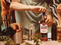 Otwieranie butelki Bacardi Spiced, rumu z naturalnymi aromatami i przyprawami, na imprezie.