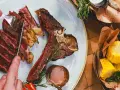 Idealne jakie wino do steka? Soczysty stek T-bone z pieczonymi kolbami kukurydzy i sosem.