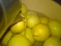 Woda z cytrynami w misce, przygotowanie do zrobienia wódki cytrynowej. Przepis na domową nalewkę.