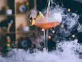 Elegancki drink z pomarańczową skórką, otoczony mgłą, idealny do nauki, jak pić bourbon.