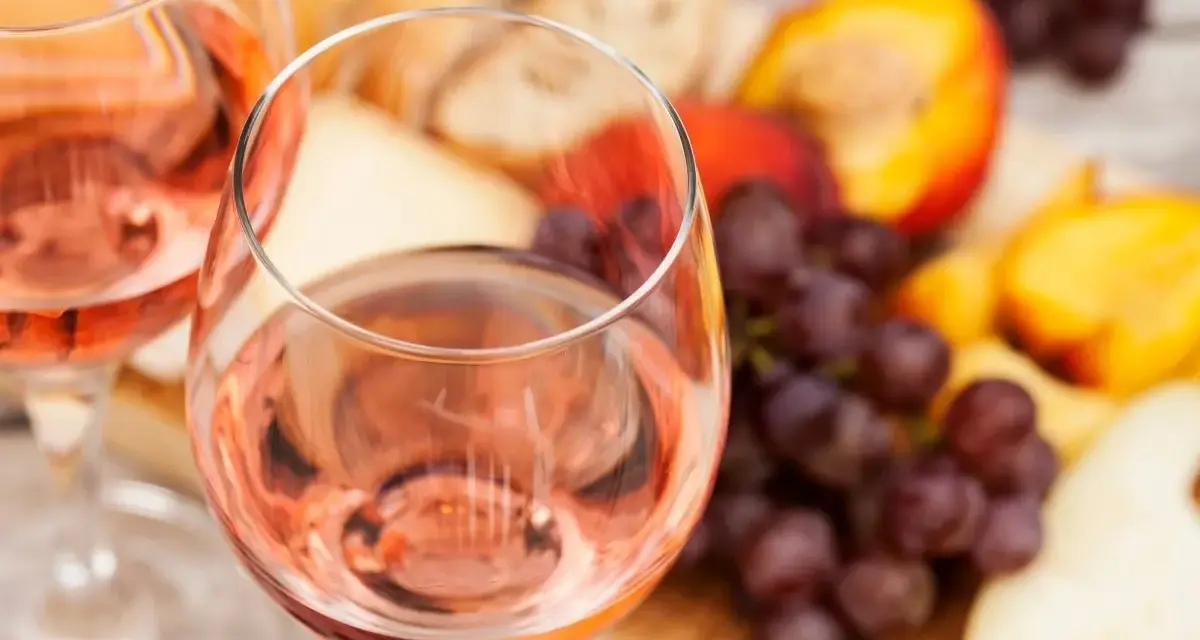 Idealny przepis na wino brzoskwiniowe: orzeźwiający różowy napój z owocami, serem i pieczywem.
