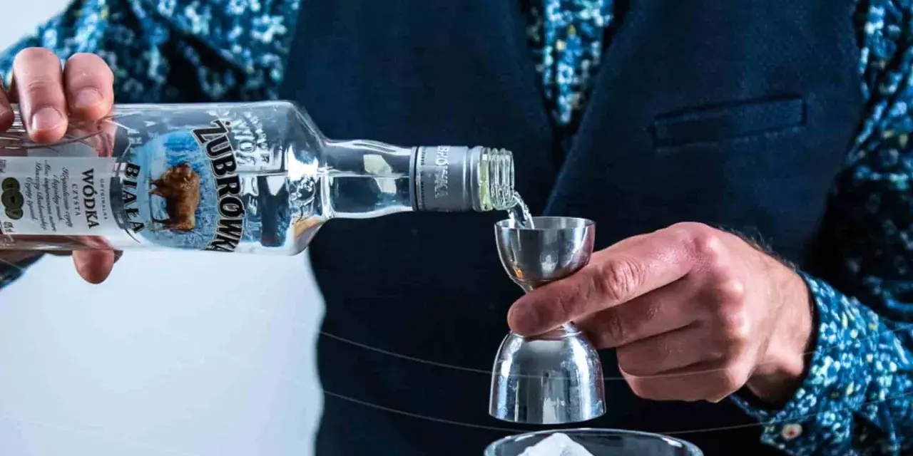 Barman nalewa Żubrówkę do kieliszka z lodem. To może być początek przygotowania drinka z jednej z top 10 wódek w Polsce.