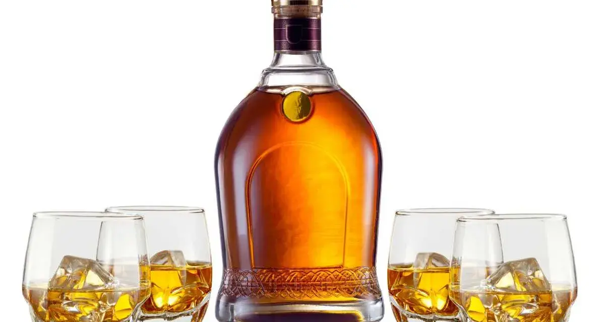 Elegancka butelka whisky i cztery szklanki z lodem. Czy to single malt czy blended, każdy znajdzie coś dla siebie.