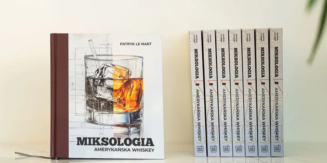 Książka "Miksologia Amerykańska Whiskey" Patryka Le Narta, z ilustracją szklanki z lodem i bursztynowym trunkiem. Obok niej rząd identycznych tomów.