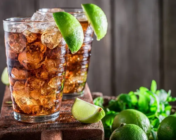 Dwa orzeźwiające drinki z rumem i lodem, ozdobione limonką. Idealne na upalne dni, zastanawiasz się, jaki rum do herbaty będzie najlepszy?