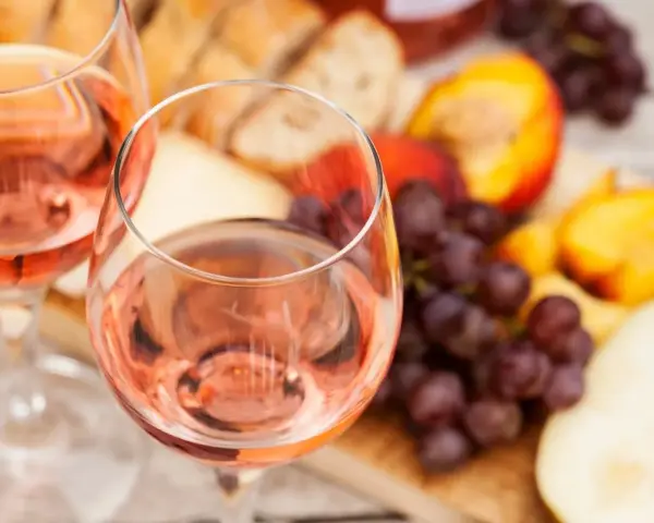 Idealny przepis na wino brzoskwiniowe: orzeźwiający różowy napój z owocami, serem i pieczywem.