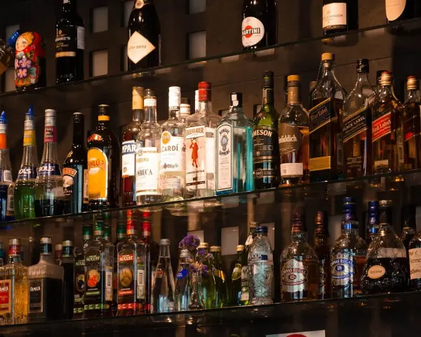 Różne rodzaje martini, szampanów i innych alkoholi na półkach baru.