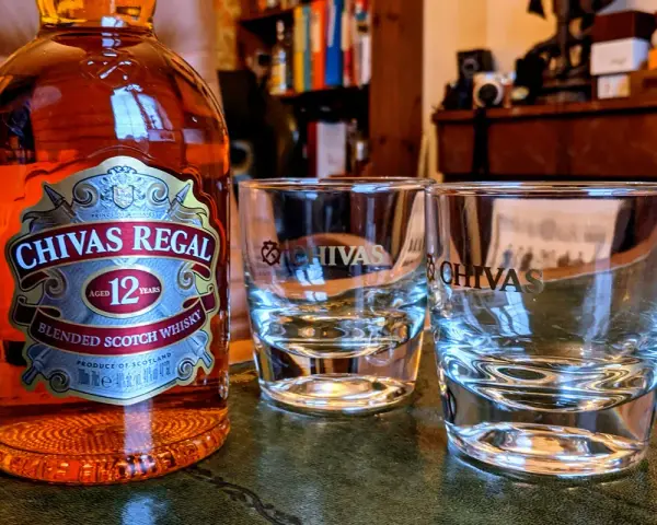 Chivas Regal 12 z czym pić? Butelka Chivas Regal 12 i dwa kieliszki, gotowe na degustację.