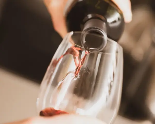 Czerwone wino nalewane do kieliszka. Czy otwarte wino się psuje? Zależy od sposobu przechowywania, ale świeżo otwarte smakuje najlepiej.