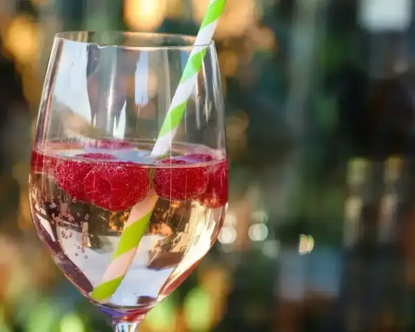 Orzeźwiający drink z malinami i słomką. Idealny na lato, gdy zastanawiasz się, z czym pić bacardi malinowe.