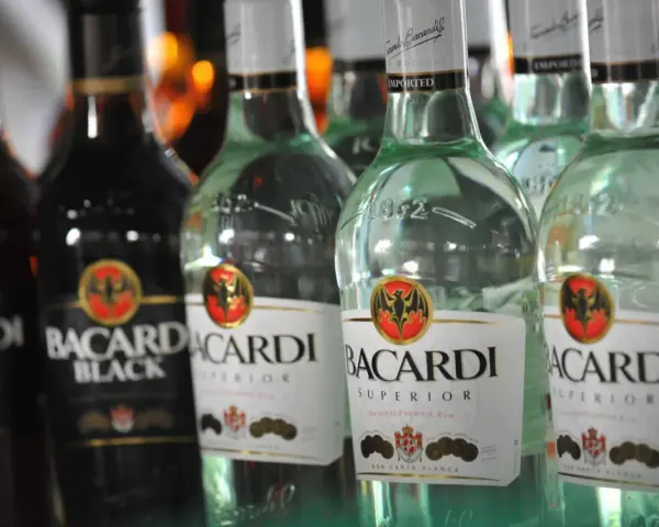 Rzędy butelek Bacardi, w tym Bacardi Black i Bacardi Superior. Bacardi to znany alkohol, rum.