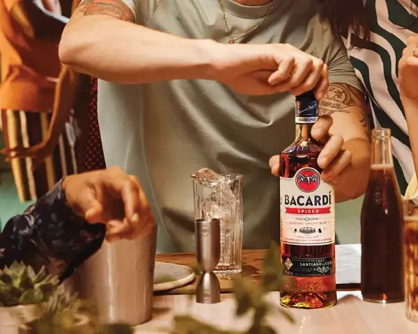 Otwieranie butelki Bacardi Spiced, rumu z naturalnymi aromatami i przyprawami, na imprezie.