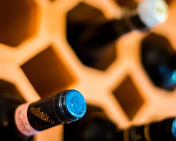 Butelki w drewnianym stojaku, jedna z etykietą "Frescobaldi". Ciekawi mnie, jak smakuje brandy.