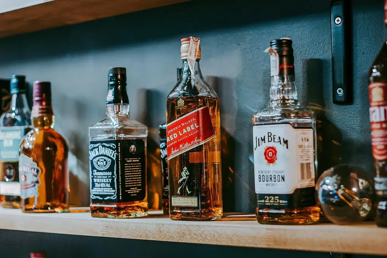 Butelki Jack Daniel's, Johnnie Walker Red Label i Jim Beam na półce. Kolekcja top 10 whisky dla konesera.