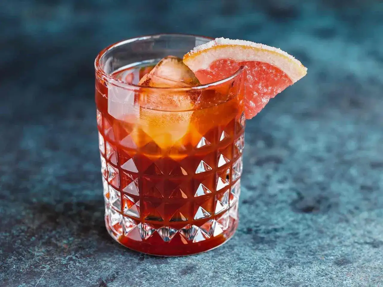Czerwony koktajl z lodem i plasterkiem grejpfruta, idealny do delektowania się chwilą. Jagdstolz z czym pić? Z tym orzeźwiającym drinkiem!