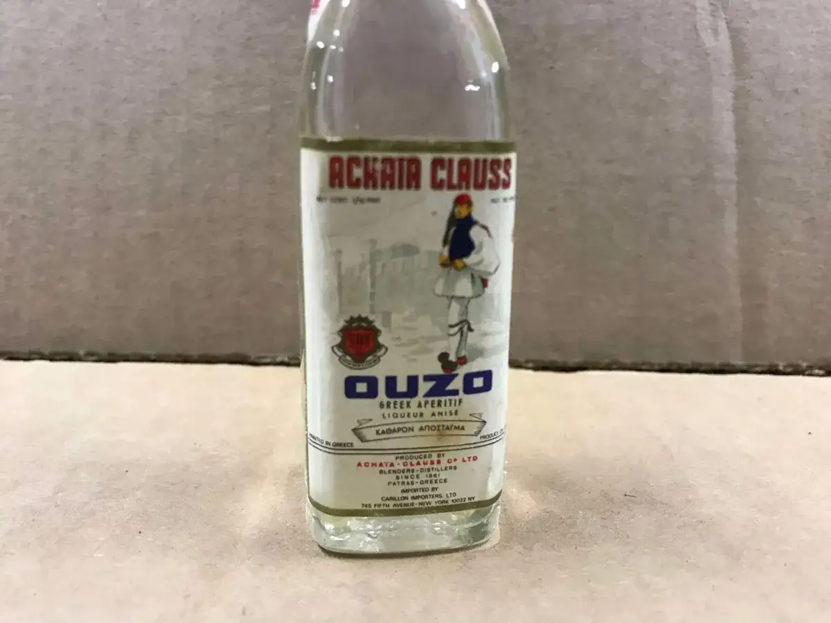 Butelka ouzo z greckim aperitifem. Etykieta informuje, że ouzo ile ma procent, ale szczegóły są nieczytelne.