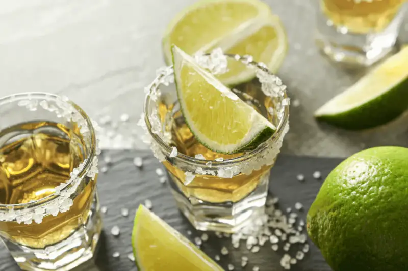 Jak pić tequilę gold? Kieliszki z solą i limonką, gotowe do degustacji.